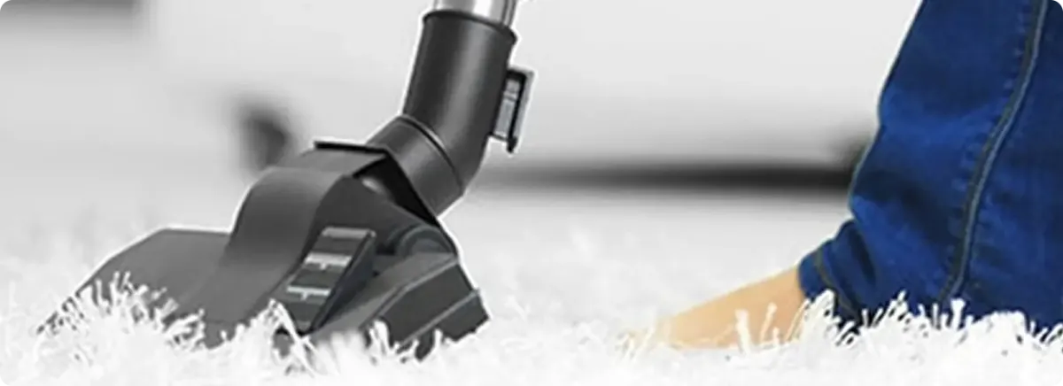 Close-up of a professional vacuuming a white carpet in Laporte.